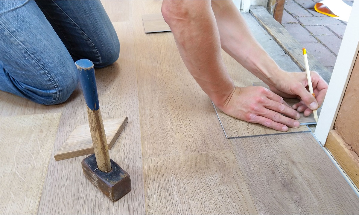 man installing vinyl flooring